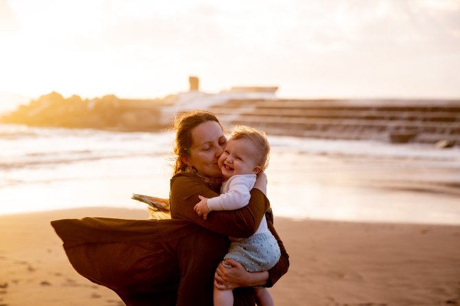 Donna con in braccio un bambino fotografata durante la golden hour