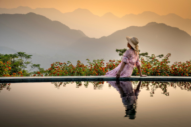 Donna a bordo piscina al tramonto
