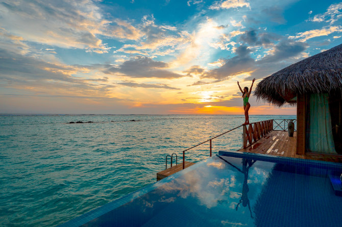 Donna a bordo piscina al tramonto