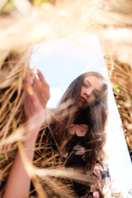Ragazza allo specchio in un campo di grano