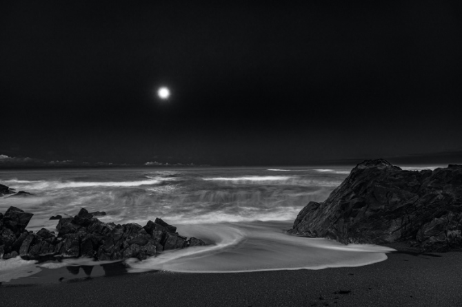 Fotografia in bianco e nero del mare notturno illuminato dalla luna