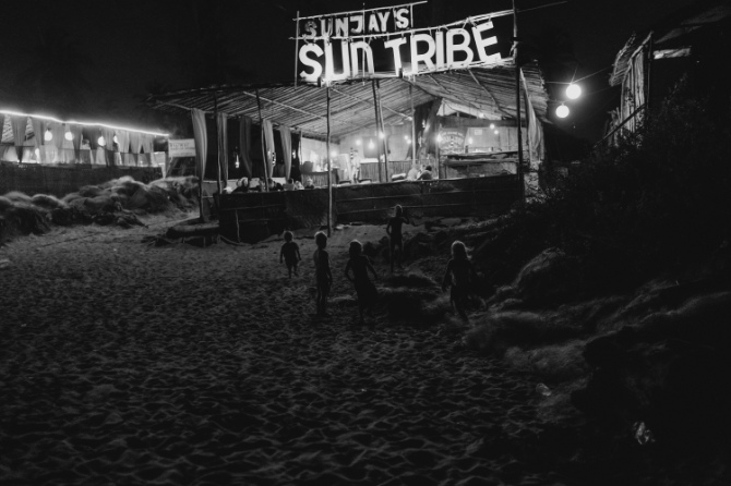 Fotografia di bambini che giocano in spiaggia di notte