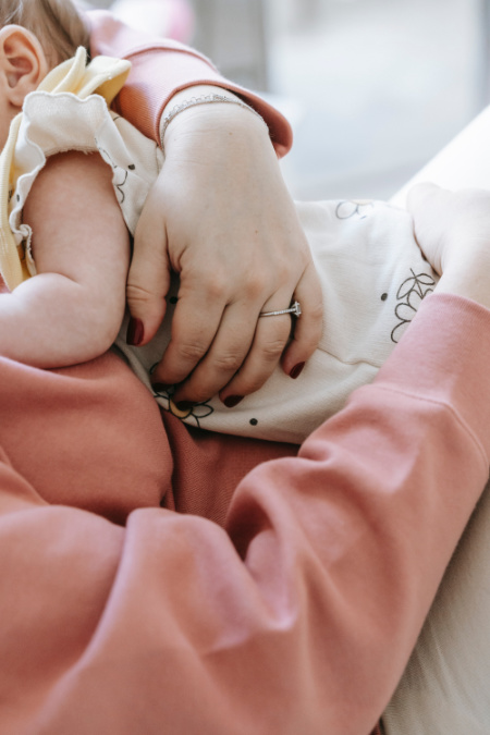 Foto dettaglio di una mamma con in braccio il figlio