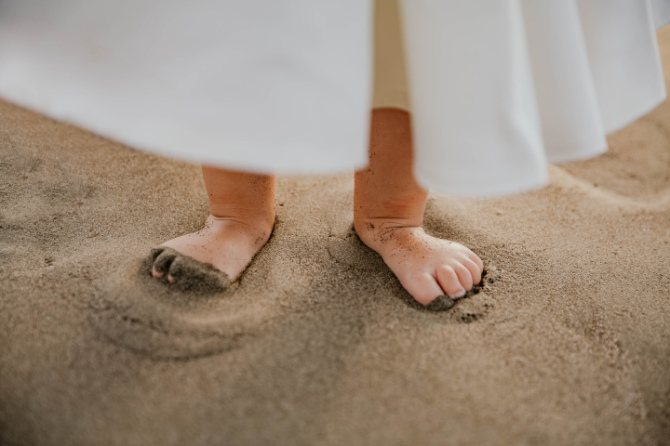 Fotografare i bambini: foto dettaglio dei piedi di una bambina sulla sabbia